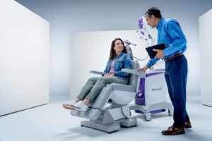 A doctor explains what is the age limit for TMS to an adult patient seated in a NeuroStar TMS therapy chair.