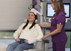 A patient receiving a NeuroStar TMS session supervised by a clinician.